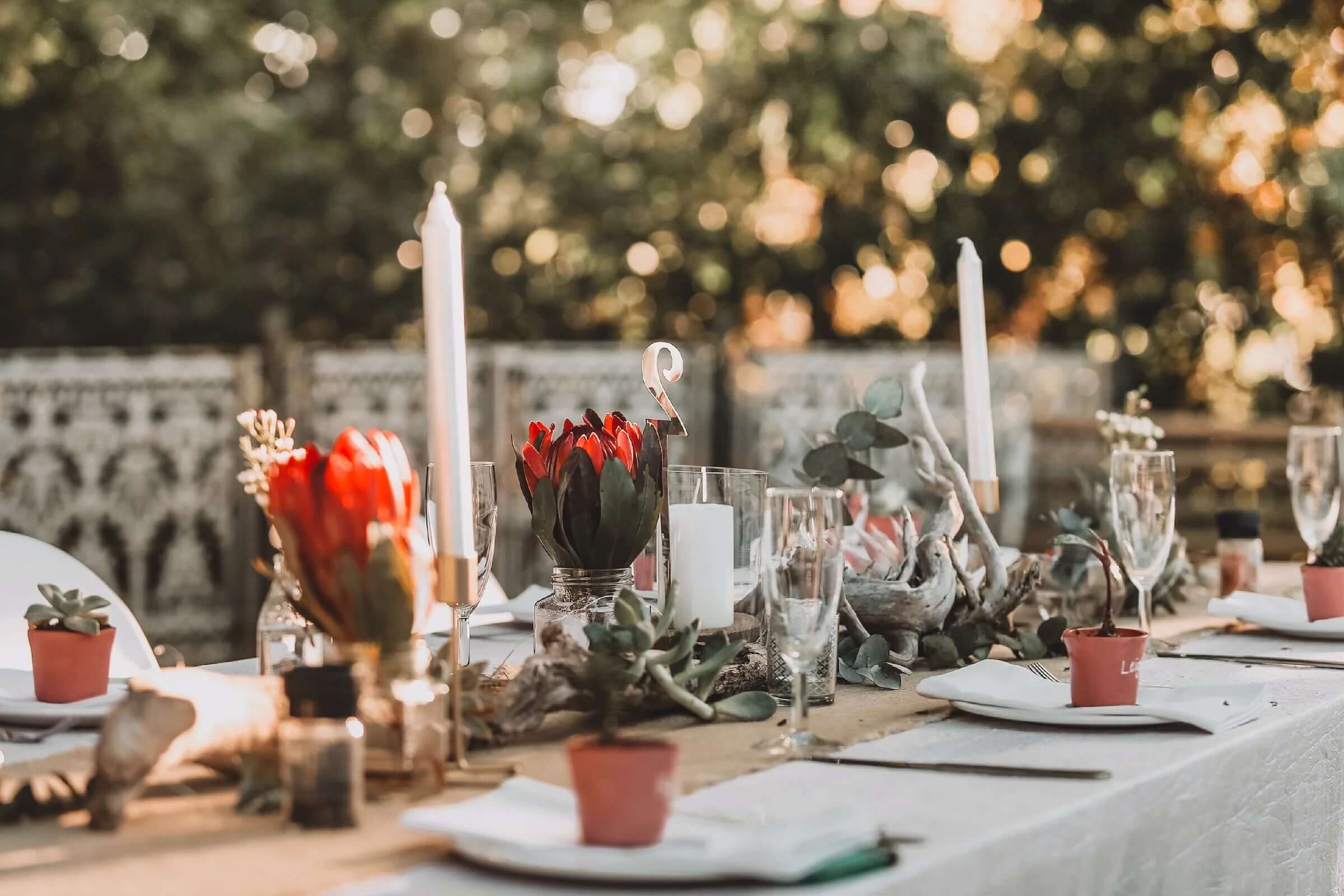 Red roses in clear vases and white taper candles